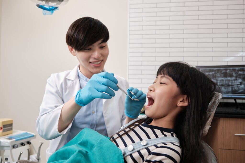 Pediatric dentist examining a young patient at Gateway Little Smiles in the St. Louis area.