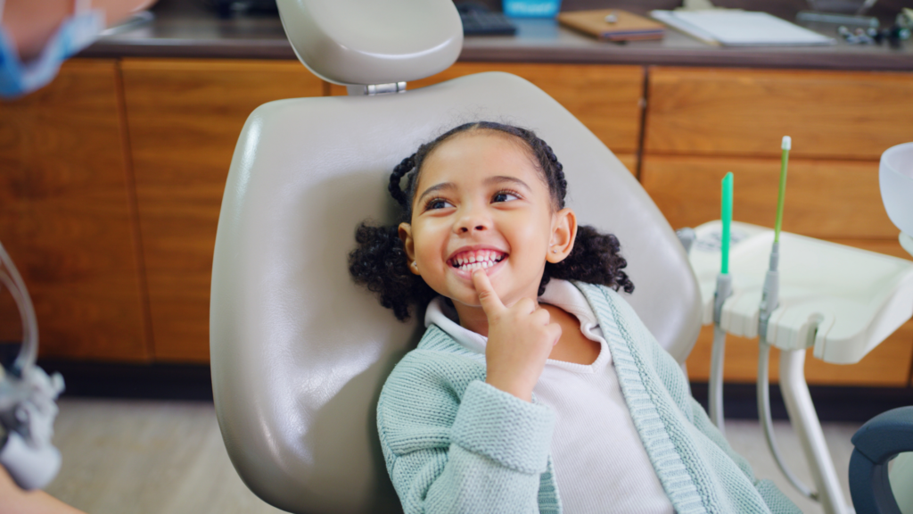 Girl patient pointing at new dental fillings in Greater St. Louis MO